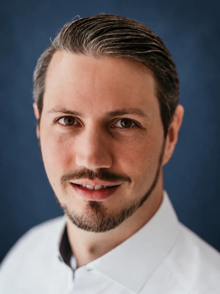 Danny Rettenmaier, Porträtaufnahme vor dunkelblauem Hintergrund